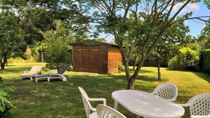 A backyard with a wooden shed, two lounge chairs, and a table with chairs. - La petite corbière ⭐⭐⭐ Between bocage and sea (Jullouville)