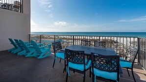 Une terrasse avec une table et des chaises, donnant sur une plage.