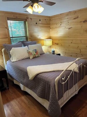 Cozy bedroom with a single bed, bedside table, and ceiling fan.