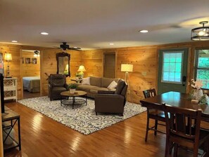 Relax in this inviting living room with a sofa set, coffee table, and dining table.