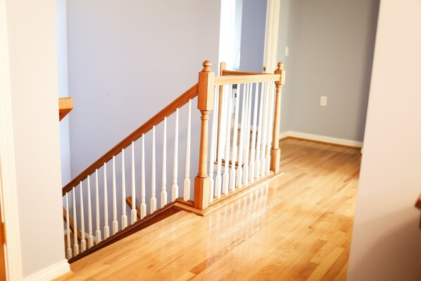 Una escalera de madera con barandillas blancas que da a una plataforma.