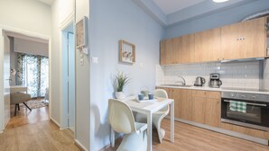 A modern kitchen with wooden cabinets, a white countertop, and a stainless steel oven. - City Nest Apartment by Cloudkeys (Athens)