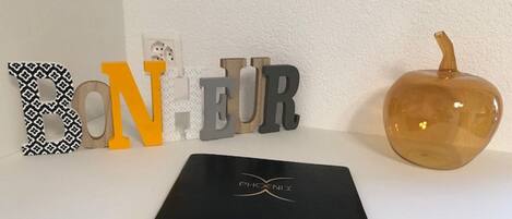 A black folder with 'PHOENIX' logo on a white surface, surrounded by decorative letters and a pumpkin.