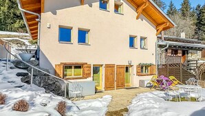 A chalet with a sloped roof, wooden beams, and a snow-covered ground. - My Cosy Flat in the Mountains (Anzère)