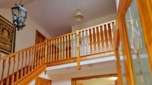 A spacious hallway with a wooden staircase leading to a second floor. - Country farmhouse sleeps 9 with enclosed garden and games barn. (Blairgowrie, Perthshire)