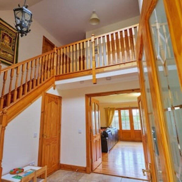 Staircase leads to an open-plan area with a view of the outdoors through large windows.