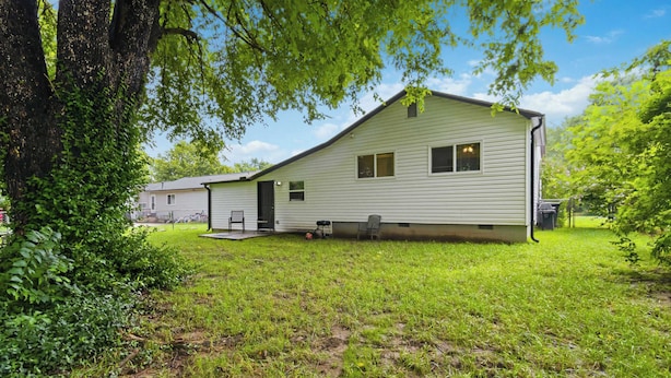 A single-story house with a front porch, a small attached garage, and a well-maintained lawn. - Spacious Renovated Home with Fenced Yard (Springdale)