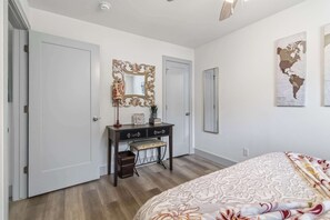 A bedroom with a bed, a dresser, a mirror, and a wall map. - Spacious Renovated Home with Fenced Yard (Springdale)