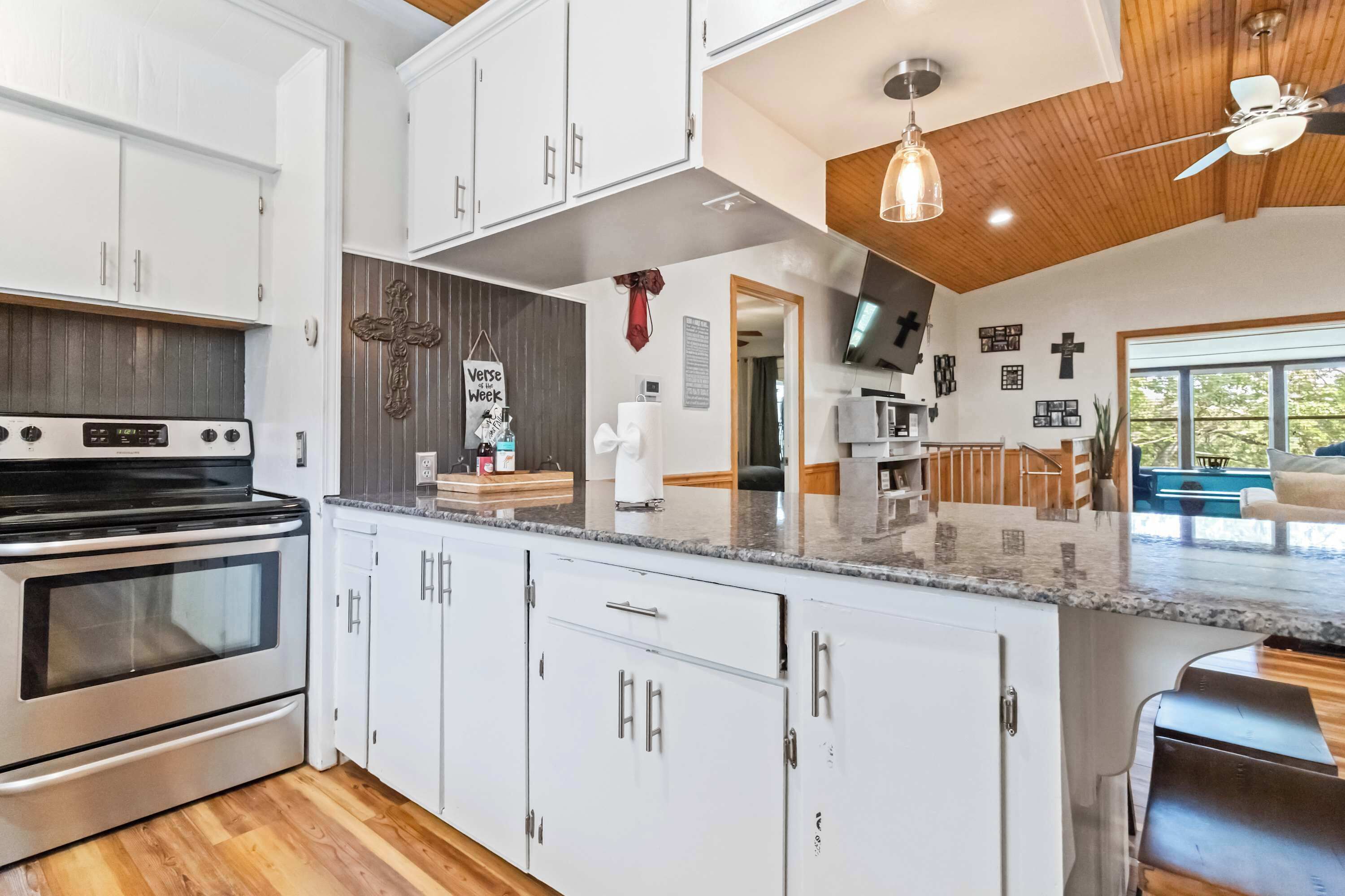 A modern kitchen with white cabinets, a stainless steel oven, and a granite countertop.
