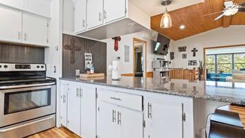 A modern kitchen with white cabinets, a stainless steel oven, and a granite countertop.