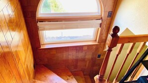 Una escalera de madera con tragaluz y barandilla de madera.