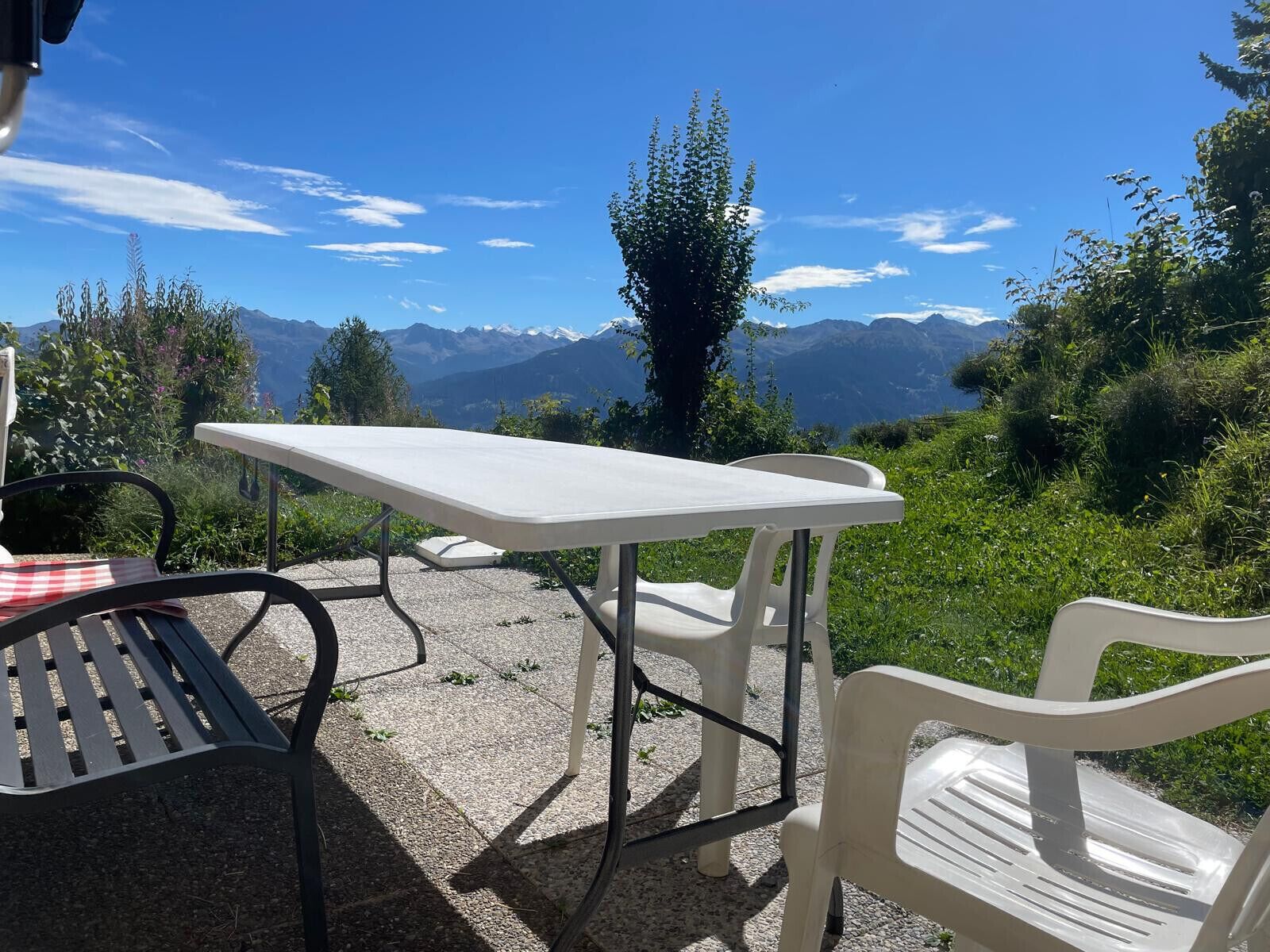 A table and chairs set outdoors with a mountain view.