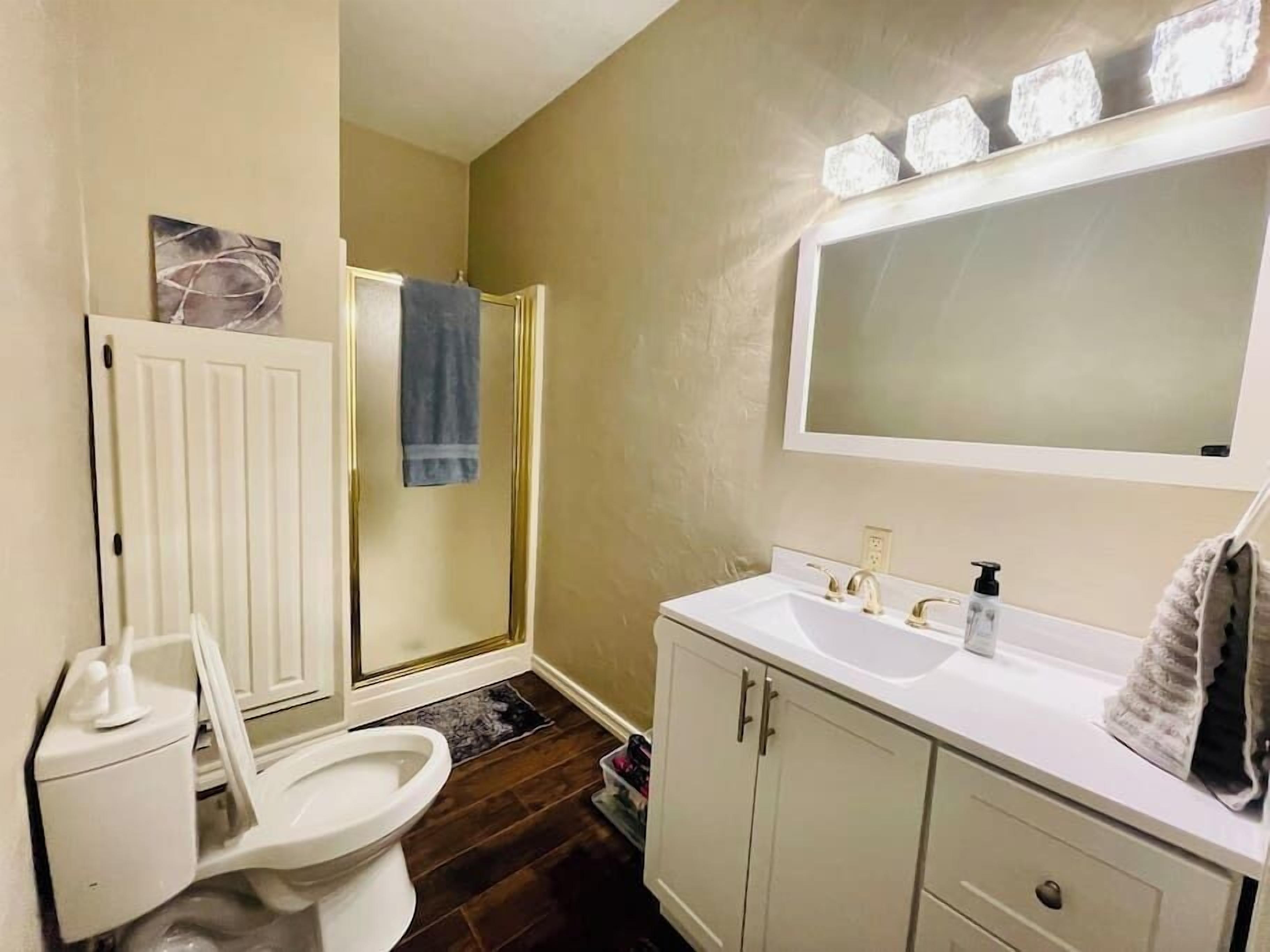 A bathroom with a toilet, sink, and shower.