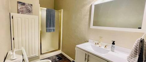 A bathroom with a toilet, sink, and shower.