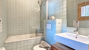 A bathroom with a bathtub, toilet, and sink.