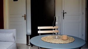 A room with a round table, a bench, a bottle, and a cork. - Quiet nest with terrace in the city center (Avignon)