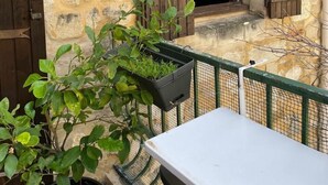 A stone building with wooden shutters, a small table, and a potted plant. - Quiet nest with terrace in the city center (Avignon)