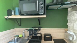 A compact kitchen with a Brandt microwave, a sink, a dish rack, and a black dishwasher. - Quiet nest with terrace in the city center (Avignon)