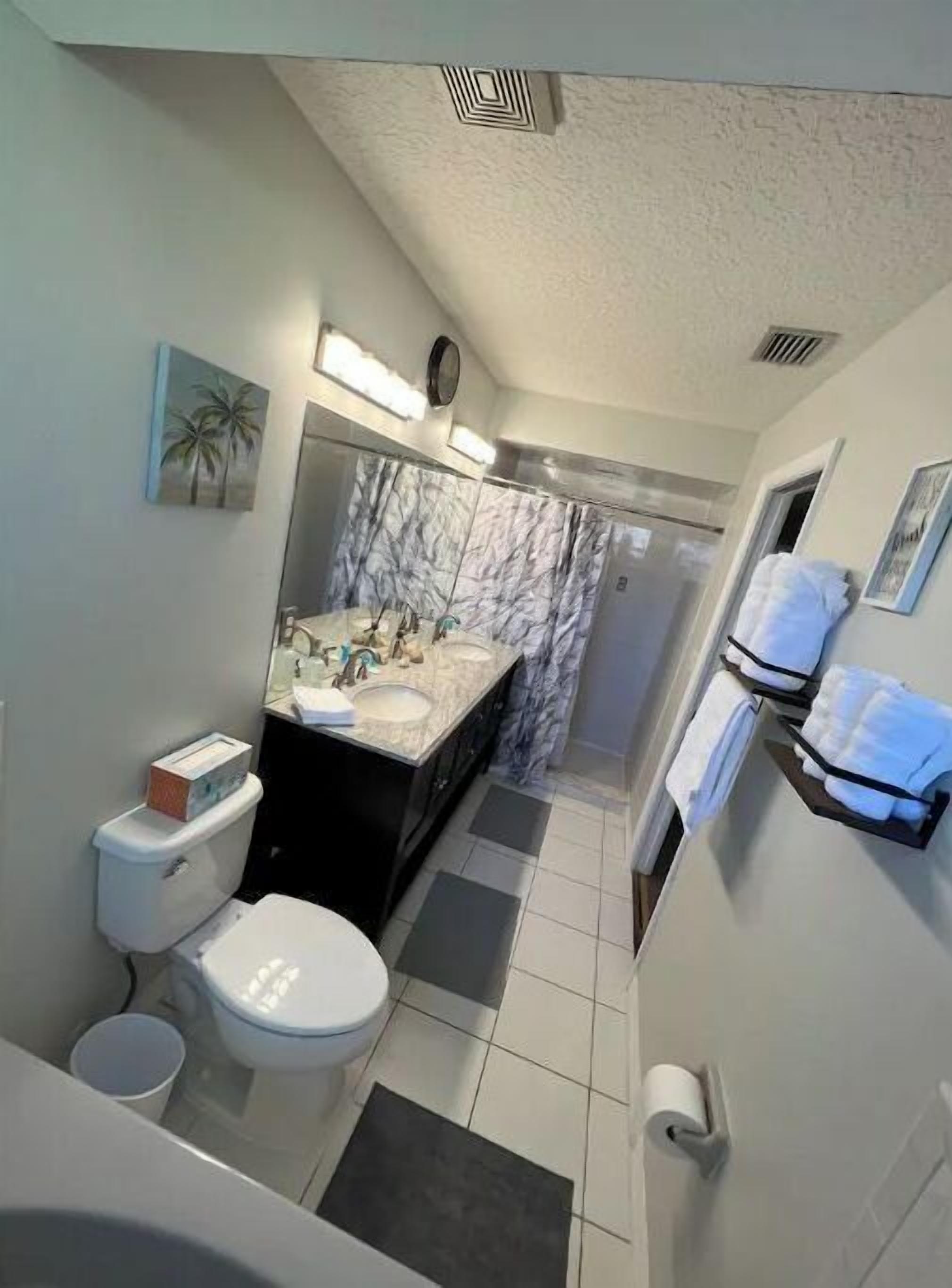 A bathroom with a toilet, sink, and shower.