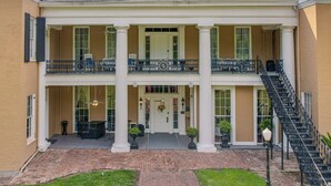 A two-story building with a central entrance, columns, and a balcony with railings. - The Inn at Cedar Grove (Vicksburg)