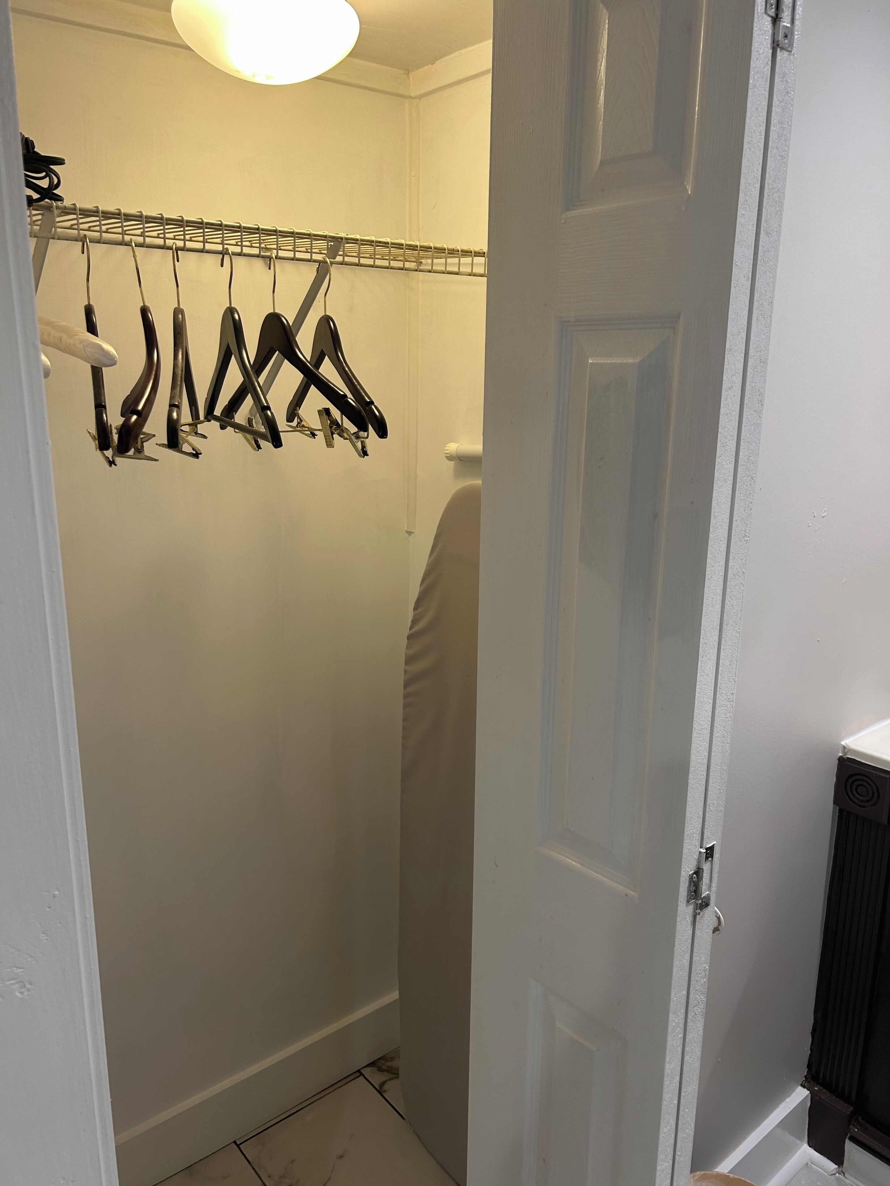 Un bagno con un portasciugamani pieno di asciugamani, un termosifone e una porta.
