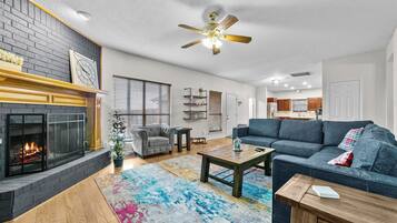 Huge great room with gas fireplace, Lovesac couch, TV that is open to breakfast nook and kitchen creates the heart of this Texas home