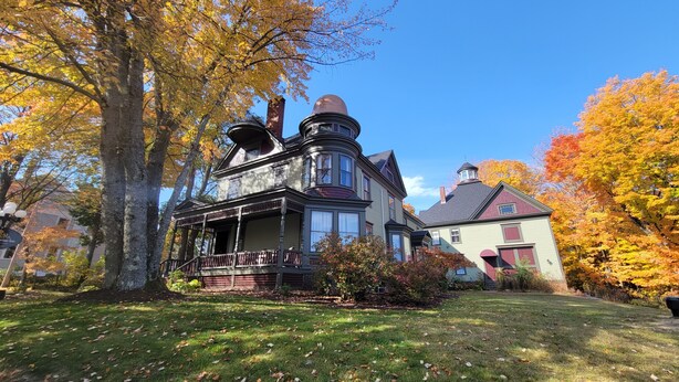 A large, historic house with a prominent turret and bay windows, surrounded by autumn foliage. - The Elizabeth Inn and Restaurant (Bethel)