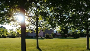 A grassy field with trees and buildings in the background. - "encantea" lovely country house - apartment "Timo" (Lucca)
