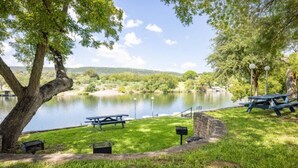 A lakeside picnic area with benches and a grill. - Condo 12, Lakefront with a Beautiful View (Burnet)