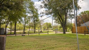 A park with a volleyball net, trees, and a picnic area. - Condo 12, Lakefront with a Beautiful View (Burnet)