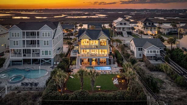 A large house with a swimming pool, multiple balconies, and a well-maintained lawn. - Palmettos & Sunshine: Oceanfront w/ Pool, Hot Tub, & Stunning Views (Garden City Beach)