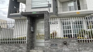 A multi-story building with balconies, a gated entrance, and a sign indicating the name "CANADI". - New, comfortable and very well equipped apartment. (Quito)