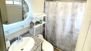 A bathroom with a sink, toilet, and shower curtain. - New, comfortable and very well equipped apartment. (Quito)