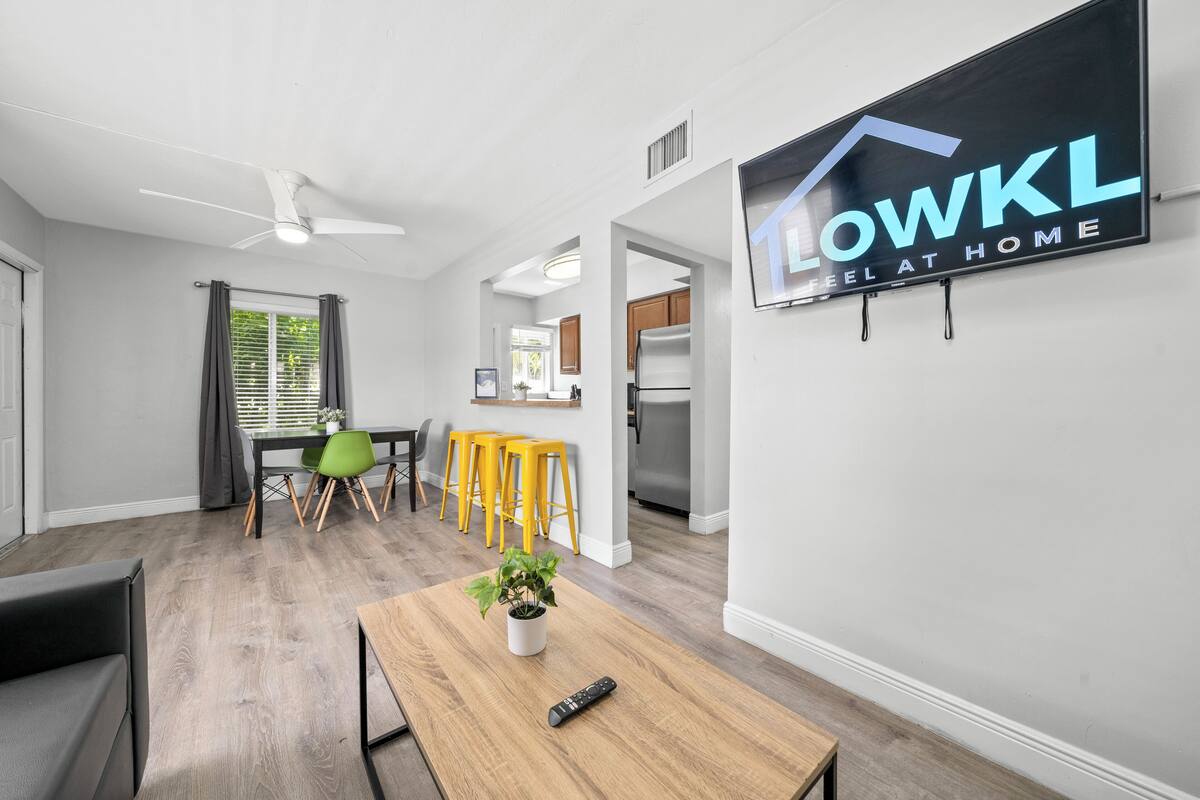 Una sala de estar moderna con comedor, cocina y un letrero que dice "LOWKL FEEL AT HOME".