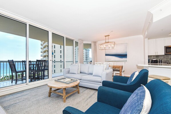 A modern living room with a sofa, chairs, a coffee table, and a balcony with a view of the ocean. - Beautiful 8th Floor Beach Views at Destin's Silver Shells! (Destin)