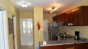 Una cocina con una isla central, electrodomésticos de acero inoxidable y armarios de madera.