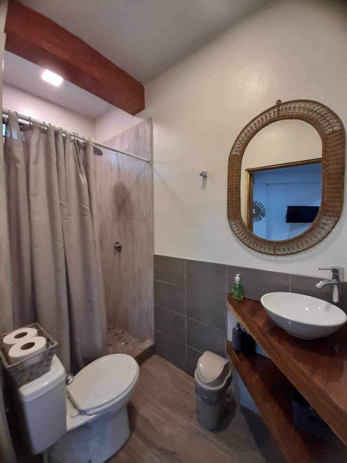 A bathroom with a shower, toilet, and sink.