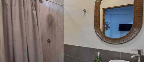 A bathroom with a shower, toilet, and sink.