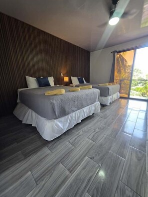 Quarto exclusivo, 2 camas Queen, sacada, vista parcial para o oceano | Wi-Fi de cortesia, roupa de cama