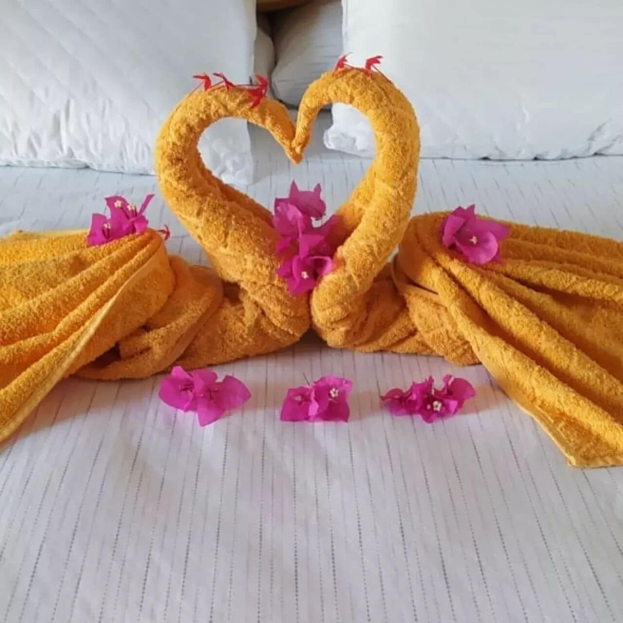 Una cama con colcha y almohadas a rayas blancas.