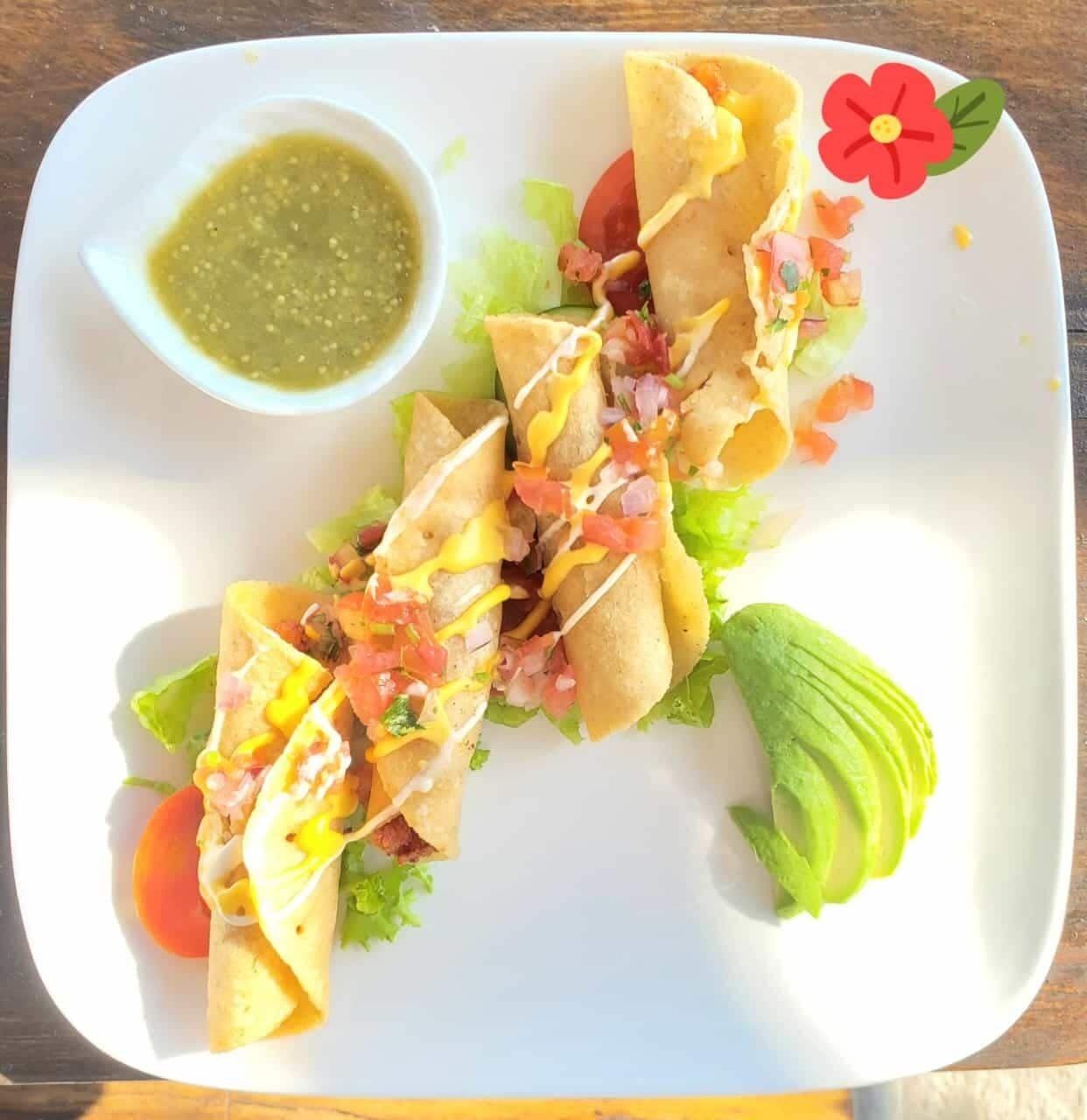 Ein Teller mit Tacos, dazu Salsa und eine kleine Schüssel Sauce.