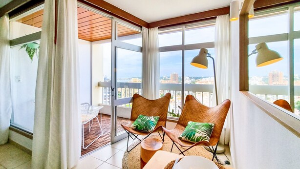 A balcony with two wicker chairs, a table, and a lamp. - FLH Portimão Bright Studio with Balcony (Portimão)