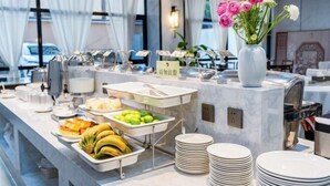 A buffet setup with various food items, a vase of flowers, and a sign indicating a price. - Yunti Hotel (Pingbian)