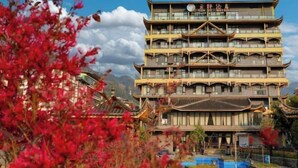A multi-story building with traditional architectural style, featuring balconies and a clear sky in the background. - Yunti Hotel (Pingbian)