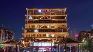 A multi-story building with traditional architectural features, including tiered roofs and illuminated signage.