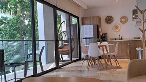 Et moderne køkken med spiseplads, store vinduer og udsigt til grønne områder.