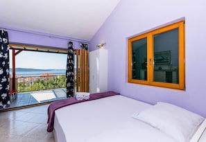 Ein Schlafzimmer mit Bett, einem Fenster mit Blick und einem Balkon mit Aussicht.