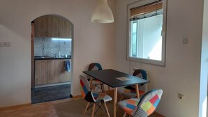 A compact kitchen with wooden cabinets and a modern pendant light. - Stunning Color 1-bed Apartment in Skopje (Skopje)