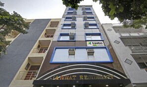 A multi-story building with balconies, air conditioning units, and a sign for 'Jannat Residency' with 'treebo' branding. - Treebo Jannat Residency (New Delhi)