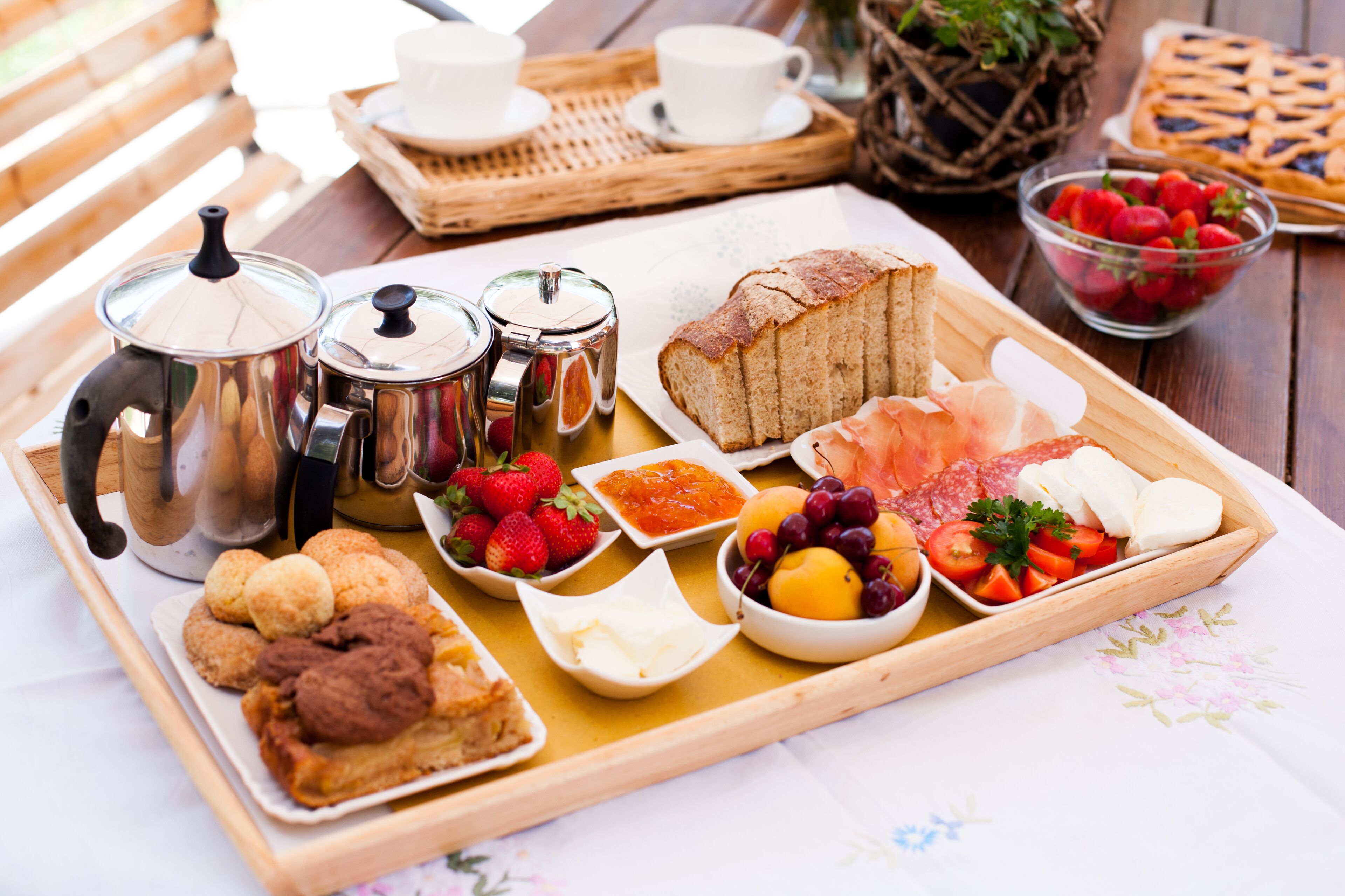 A breakfast tray with pastries, fruits, and condiments.